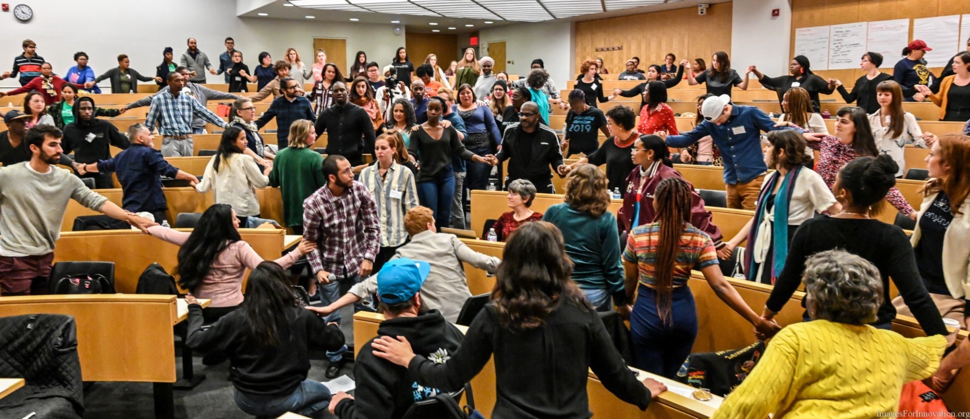 Image of theatre of change course. Participants are holding hands. 